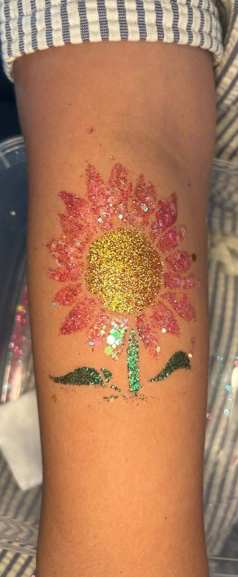 Flower glitter tattoo on a child at a Texas party